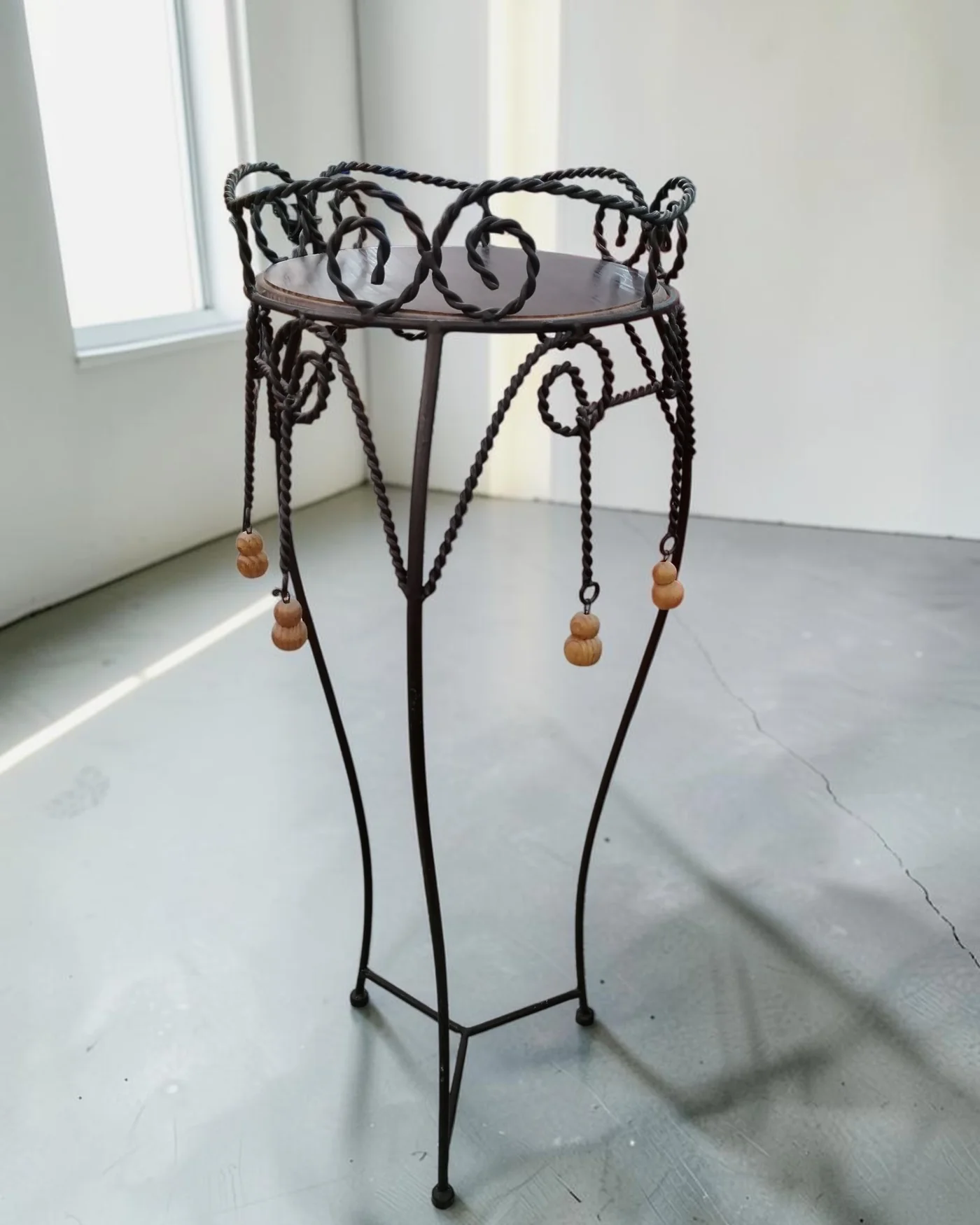 Mesa auxiliar de pie de hierro forjado con detalles decorativos - imagen 1