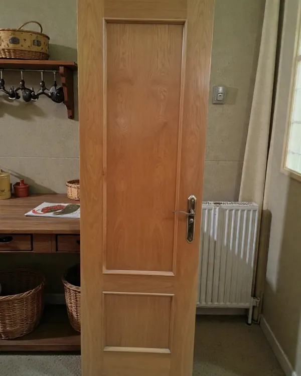 Puerta de madera interior con herrajes de latón