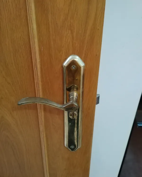Puerta de madera interior con herrajes de latón