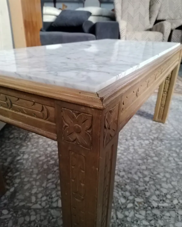 Mesa de centro rectangular con tapa de mármol y estructura de madera tallada