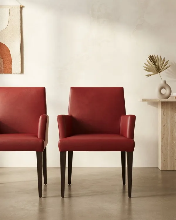 Par de sillas de comedor con tapizado en piel sintética roja y patas de madera oscura